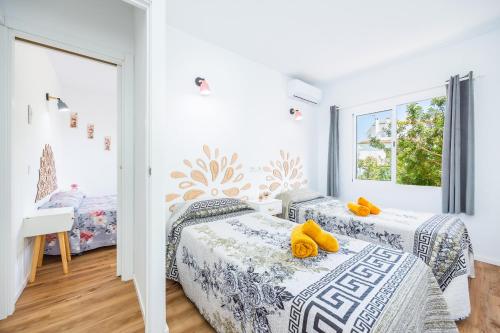 ein Schlafzimmer mit zwei Betten und einem Fenster in der Unterkunft Gran Sol Family 5 in Cala Ferrera