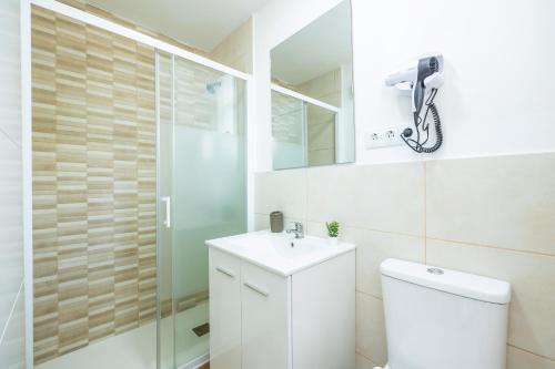 ein Badezimmer mit Toilette, Waschbecken und Dusche in der Unterkunft Gran Sol Family 5 in Cala Ferrera