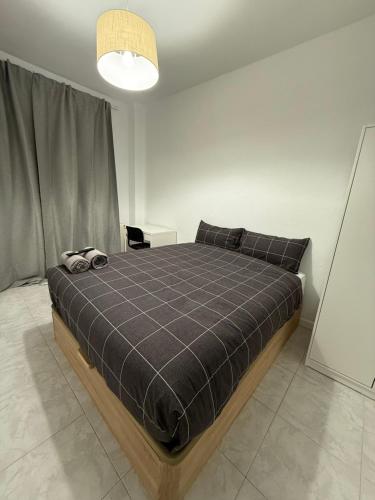een slaapkamer met een bed met een zwarte deken bij Onlyroom Madrid Calatrava in Madrid