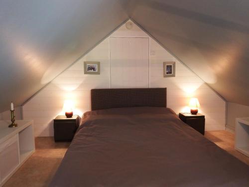 1 dormitorio con 1 cama y 2 luces en las mesas en La petite saugère en Bosguérard-de-Marcouville