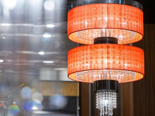 two orange lights are hanging from a ceiling at APA Hotel Asakusa Kuramae in Tokyo