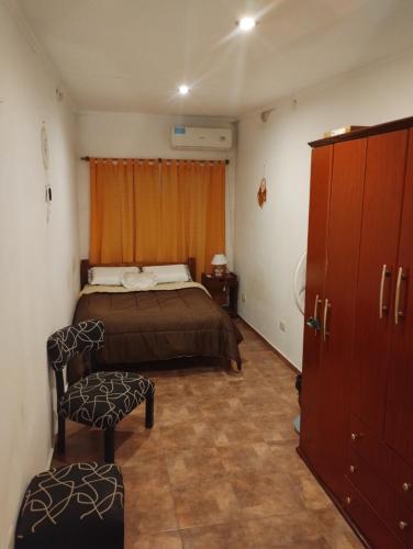 una camera da letto con un letto e una sedia di Departamento céntrico con cochera a Gualeguaychú