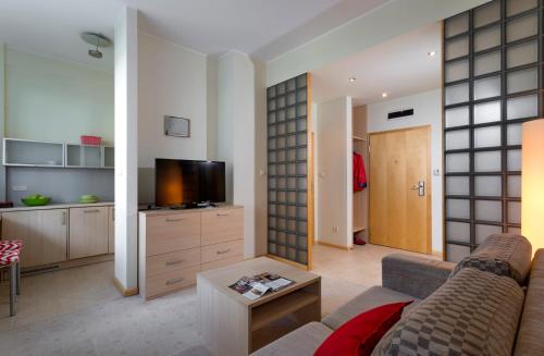 a living room filled with furniture and a tv at Apartamenty Media Park in Warsaw