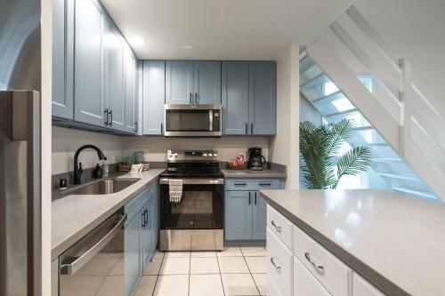 een keuken met witte kasten en een spoelbak bij Kuilima West 101 condo in Kawela Bay