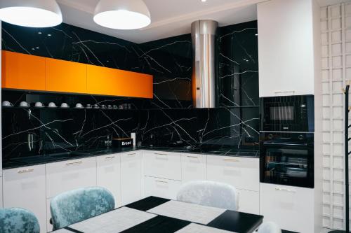 een zwart-witte keuken met een tafel en stoelen bij Amarus Apartments in Gjirokastër