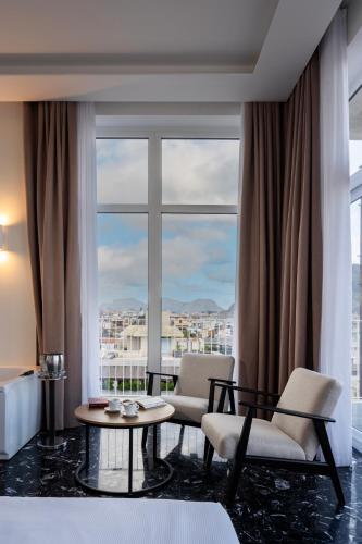 a room with two chairs and a table and a large window at Skyline Boutique Hotel in Palermo