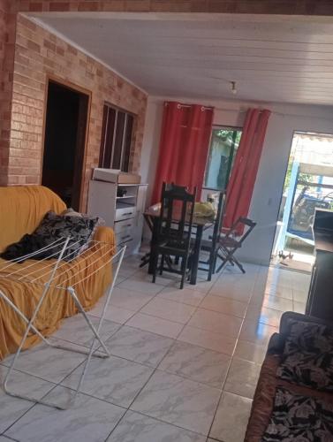 - un salon avec des rideaux rouges, une table et des chaises dans l'établissement Casa próximo a praia do morro, à Guarapari