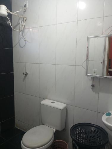 een badkamer met een toilet, een wastafel en een spiegel bij Casa próximo a praia do morro in Guarapari