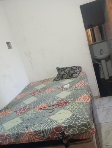 een bed met een quilt erop in een kamer bij Casa próximo a praia do morro in Guarapari