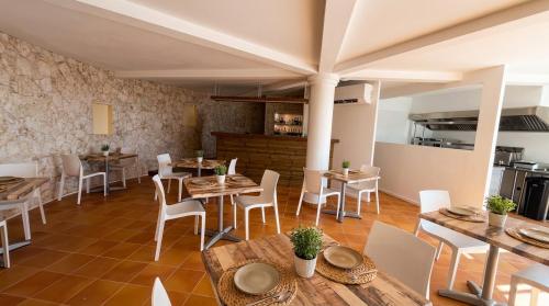 uma sala de jantar com mesas de madeira e cadeiras brancas em Pearl of Paradise em Saint Martin