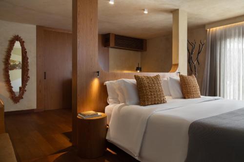 a bedroom with a large white bed and a window at Íz Hotel Conceito in Goiânia