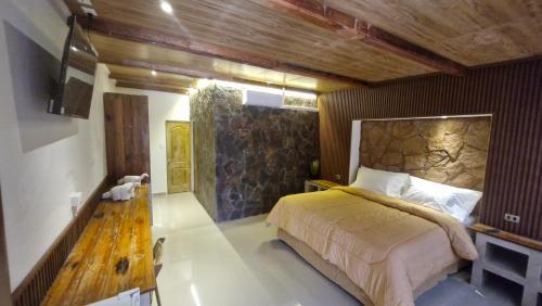 um quarto com uma cama grande e uma parede de madeira em Hotel Toconar em San Pedro de Atacama