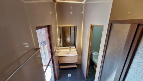 um banheiro com uma pia, um vaso sanitário e um espelho em Hotel Toconar em San Pedro de Atacama