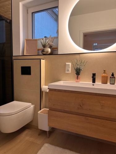 een badkamer met een wastafel, een toilet en een spiegel bij Zeile Zwei - Kloster Zinna in Jüterbog