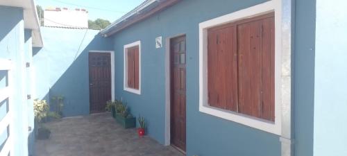 una casa blu con due porte e una scala di Casa con parque para 5 personas a Miramar