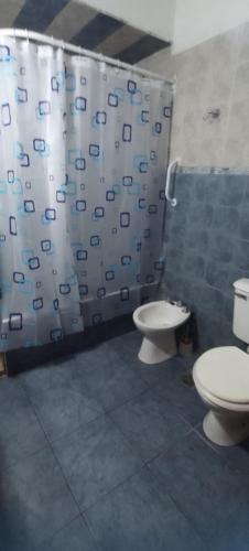 a bathroom with two toilets and a shower curtain at Casa con parque para 5 personas in Miramar