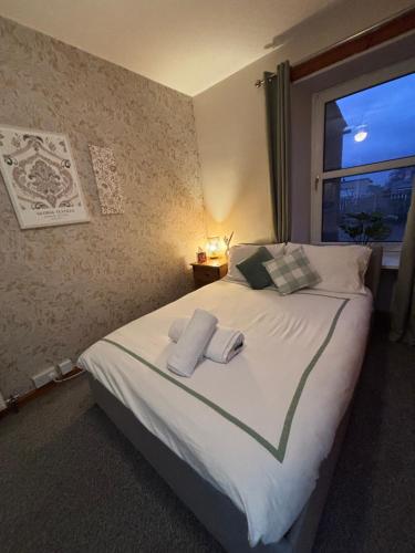 een slaapkamer met een groot bed met handdoeken erop bij Ramsay Lane in Lossiemouth