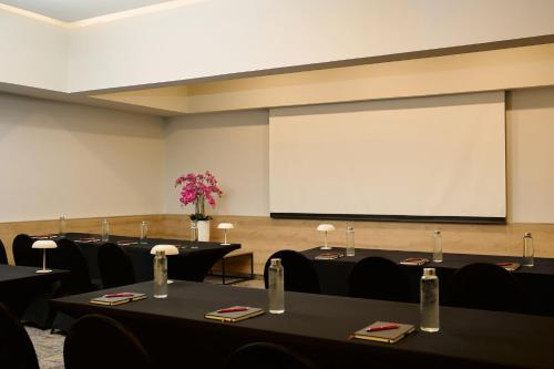 a conference room with tables and a projection screen at Fiesta Inn Monterrey Valle in Monterrey