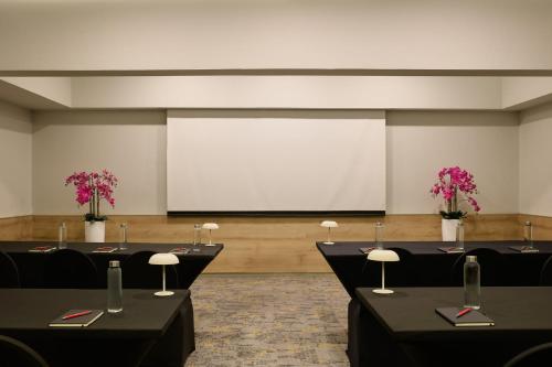 a conference room with tables and a projection screen at Fiesta Inn Monterrey Valle in Monterrey