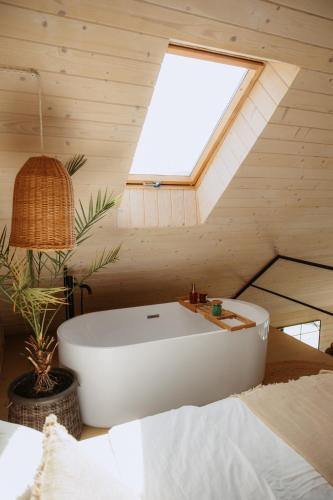 a white bath tub in a room with a skylight at Villa Lis in Ivano-Frankivsk