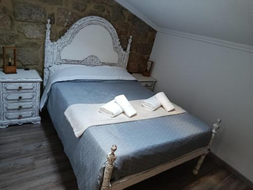a bedroom with a bed with two towels on it at CriCastelo - Alojamento Local in Trancoso