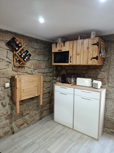 a kitchen with a white refrigerator and a microwave at CriCastelo - Alojamento Local in Trancoso