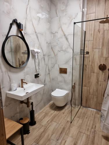 ein Badezimmer mit Toilette, Waschbecken und Dusche in der Unterkunft Apartament z tarasem in Kutno