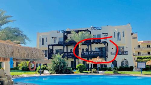 a building with an umbrella in front of a pool at Family Holiday 2 Bedroom Chalet with free Beach & Pool in Sharm, Egypt in Sharm El Sheikh