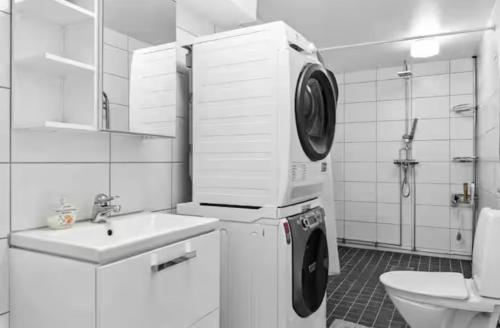 a bathroom with a washing machine and a sink at Rymligt och härligt radhus i Göteborg in Gothenburg