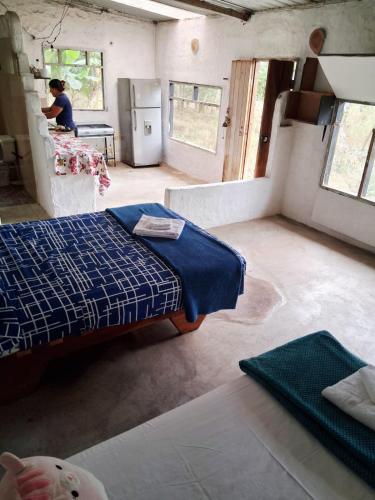 een kamer met twee bedden en een vrouw in een keuken bij La Loma in Bellavista