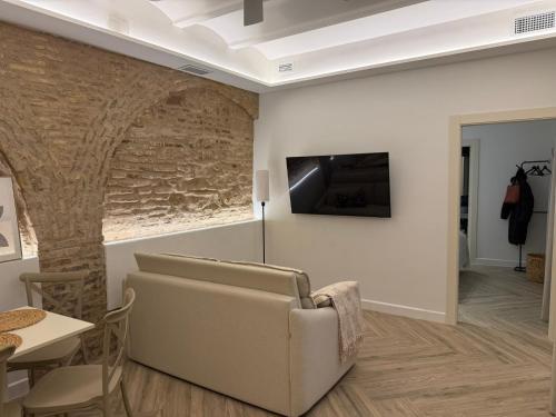 ein Wohnzimmer mit einem Sofa und einem Fernseher an der Wand in der Unterkunft Arcos de Santa Marta in Córdoba