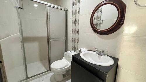 un bagno con un water, un lavandino e uno specchio di Hotel Zoe a Sampués