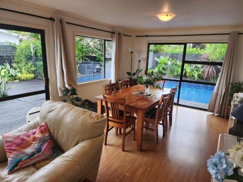 a living room with a table and chairs and a couch at Peppertree in Tauranga