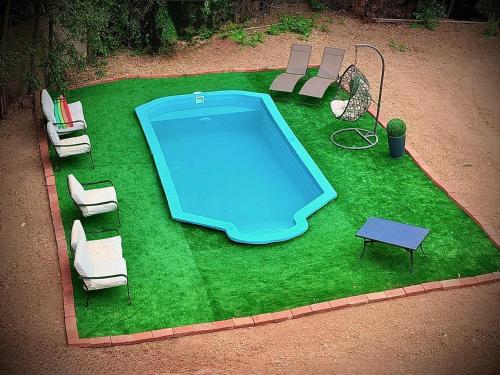 an aerial view of a pool with chairs and a table at Hostal Almares in Pichilemu