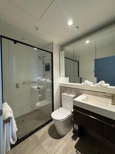 a bathroom with a toilet and a shower and a sink at Evermore Apartments in Melbourne