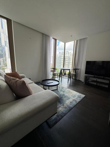 a living room with a couch and a flat screen tv at Evermore Apartments in Melbourne