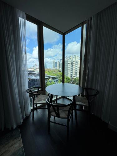 a table and chairs in a room with a large window at Evermore Apartments in Melbourne