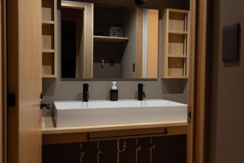 a white sink in a bathroom with a mirror at 久乃家 in Matsue