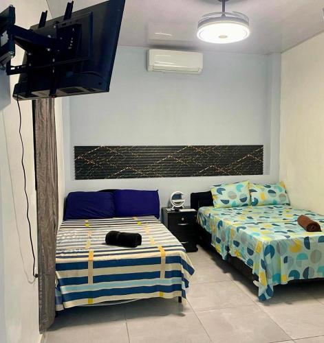 Evolution Home في Astoria: غرفة نوم بها سريران وتلفزيون بشاشة مسطحة