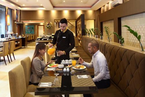 a group of people sitting at a table in a restaurant at City Garden Suites Manila in Manila