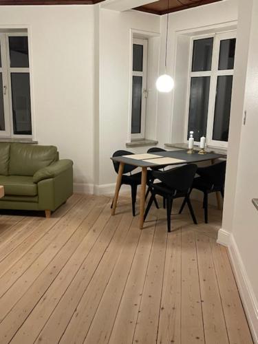 a living room with a table and a couch at Stay in Graasten - surrounded by royal peace and history in Gråsten