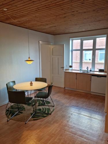 a room with a table and chairs and a kitchen at Stay in Graasten - surrounded by royal peace and history in Gråsten