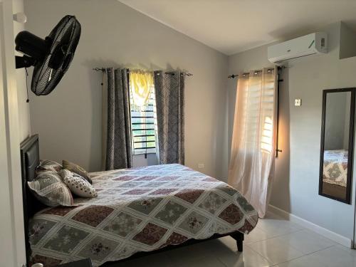 una camera da letto con un letto e una finestra di New Cozy Entire home 2 Bedroom- AC, Wifi, 24 hour Security in Private Gated Community a Old Harbour