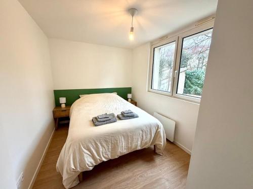 ein Schlafzimmer mit einem Bett, auf dem zwei Handtücher liegen in der Unterkunft Le chateau d'Altheis in Dole