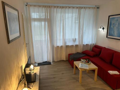 un soggiorno con divano rosso di fronte a una finestra di Relax 2 a Goslar