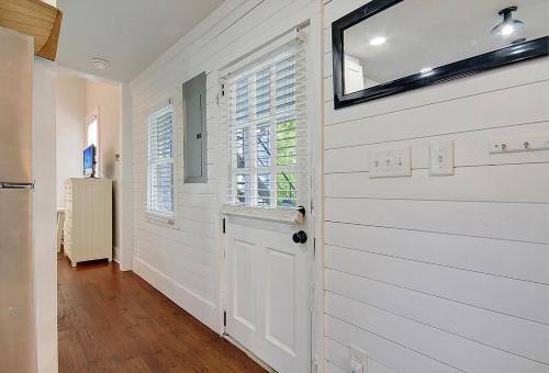 einen Flur mit einer weißen Tür und einem Fenster in der Unterkunft 4 Blocks from King Street, Classic, Cool, Quiet in Charleston
