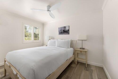 una camera da letto bianca con un letto e un ventilatore a soffitto di The Franciscan Hotel a Santa Barbara