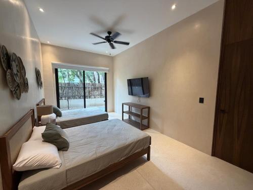 ein Schlafzimmer mit zwei Betten und einem Deckenventilator in der Unterkunft Calakmul Tulum in Cedro