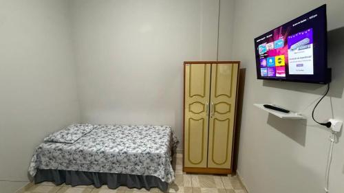 une chambre avec un lit et une télévision à écran plat dans l'établissement Hotel Colombo, à São Lourenço