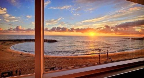 a view from a window of a beach at sunset at Sokcho 828 Spa Pension in Sokcho